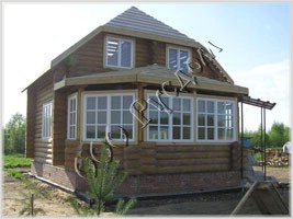 Фотография двухэтажного деревянного дома с застекленой рубленой верандой
